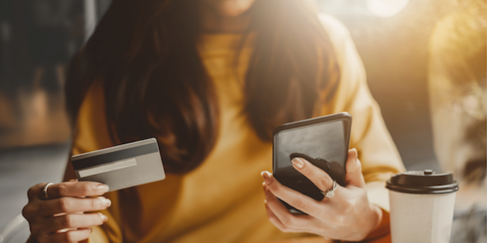 woman holding phone and credit card