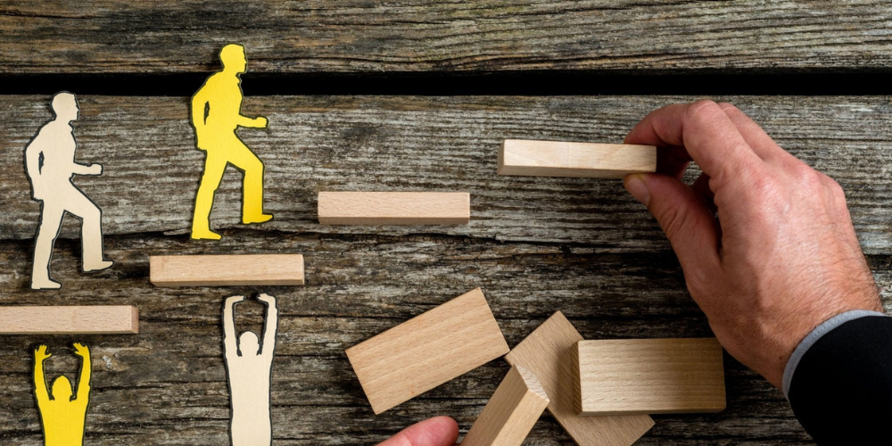 multiple cutout figures climbing steps in process of being put in place