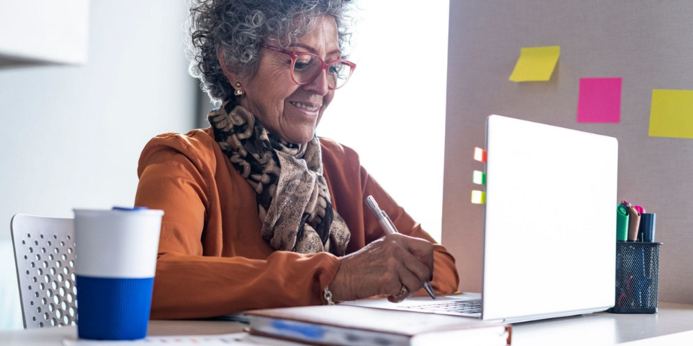 older African American woman at desk with laptop